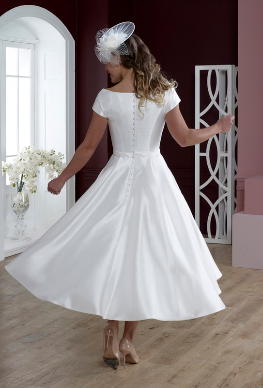Luxurious tea length wedding gown with high buttoned back.
